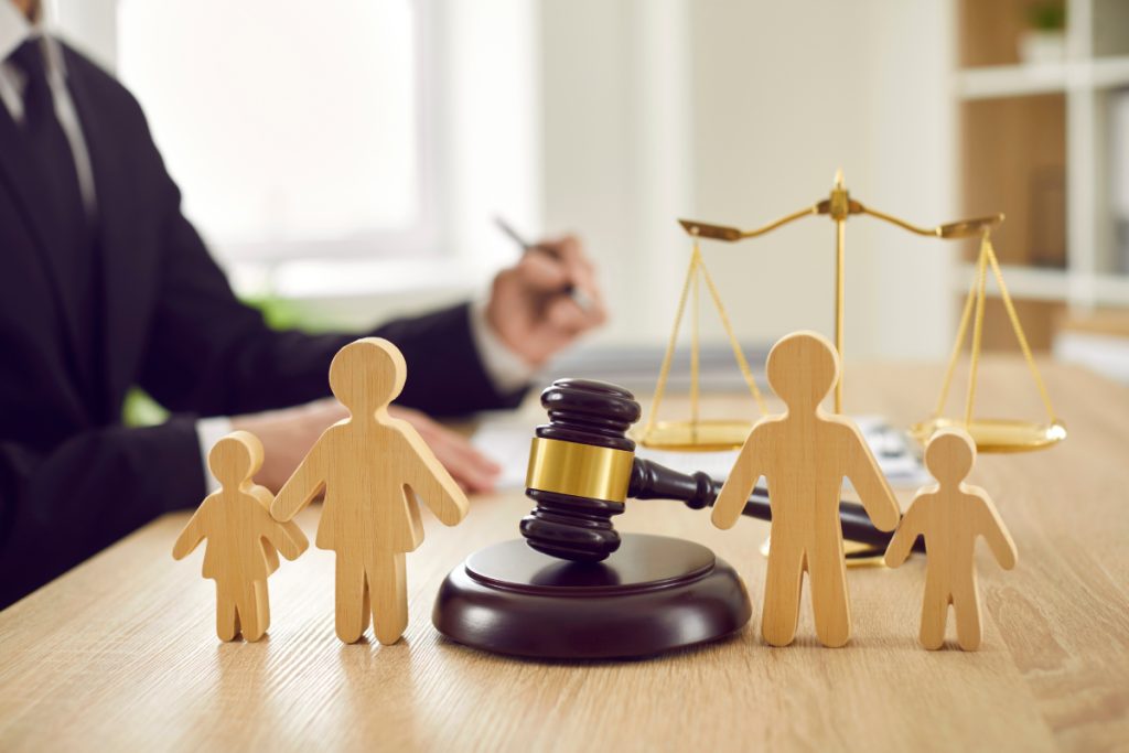family law lawyer with a gavel of justice and wooden family figures