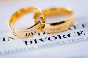 wedding rings on top of a divorce document