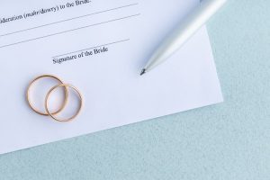 premarital agreement document with jewelry and a pen on top of it