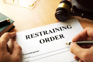 person signing a restraining order document that their protective or restraining order lawyer in austin gave to them