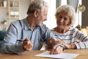 couple signing documents getting ready to speak to a wills and trusts lawyer in austin