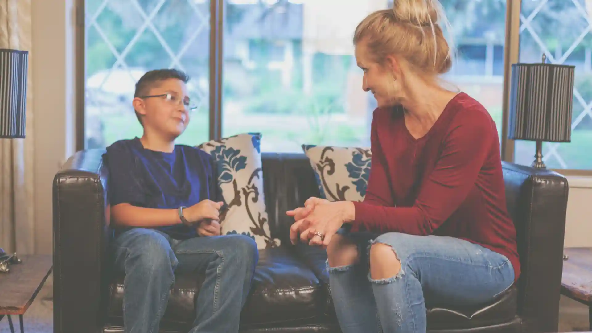 foster parent speaking to a foster child in texas while sitting on a couch