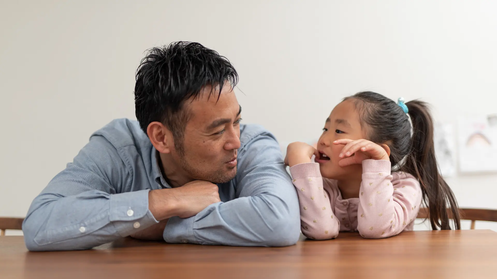 a man and their child looking at each other while smiling