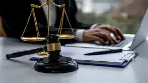 an adoption attorney writing on the laptop with a gavel and scales on a table