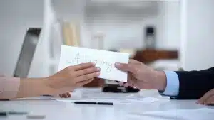 a person handing over an envelope with alimony money in it to another person