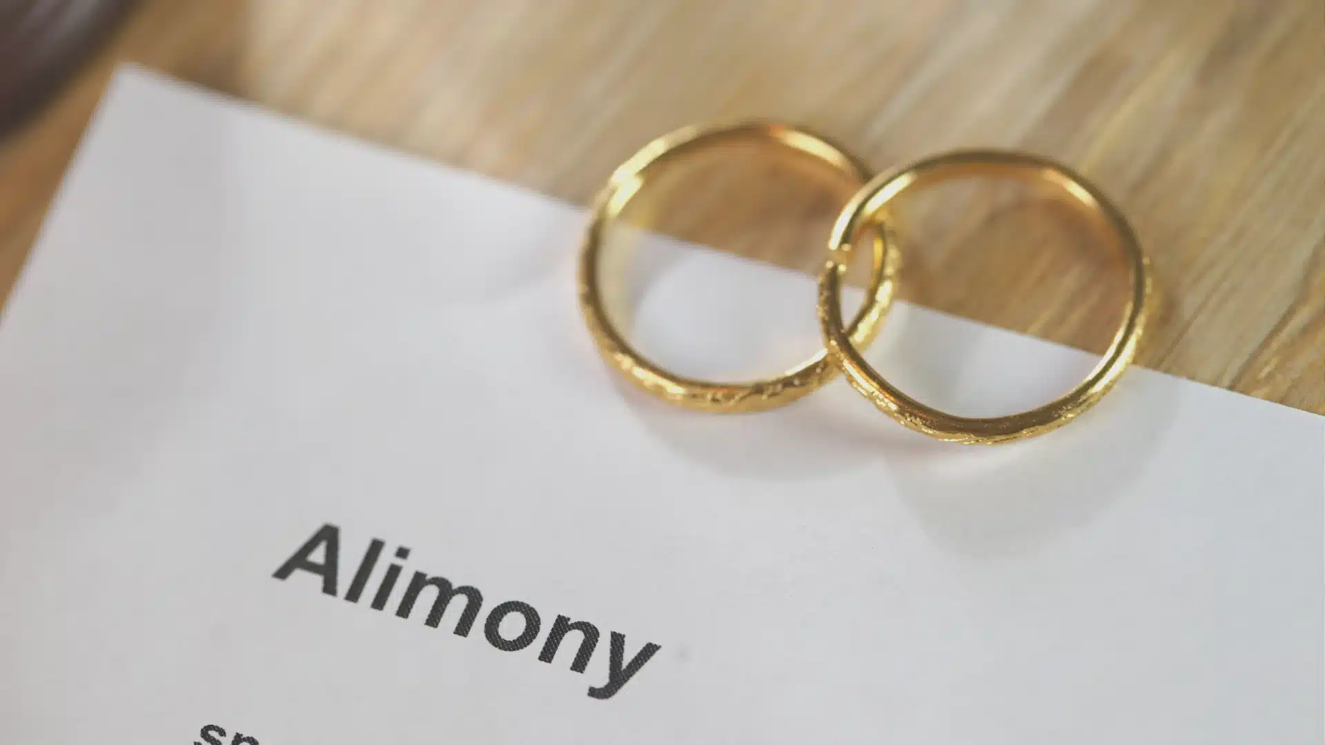 two gold wedding rings sitting on top of a piece of paper wondering if is alimony taxable in texas