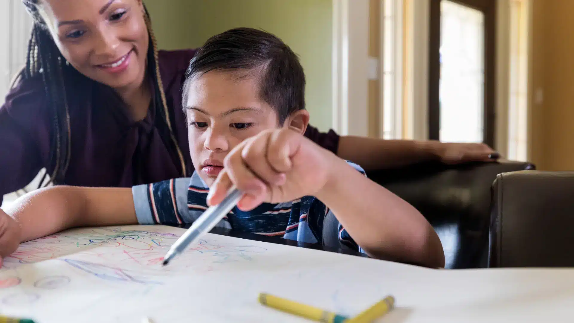 a woman guiding a special needs adoption child with their school work