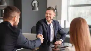 child support modification lawyer shaking the hand of a client and his wife by his side