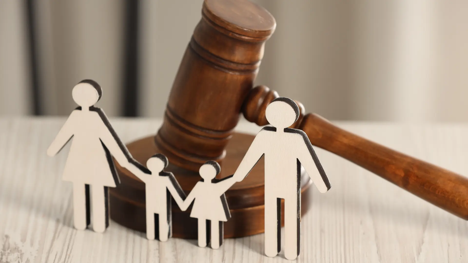 Judge’s gavel behind paper cutout family figures, representing family law and child custody