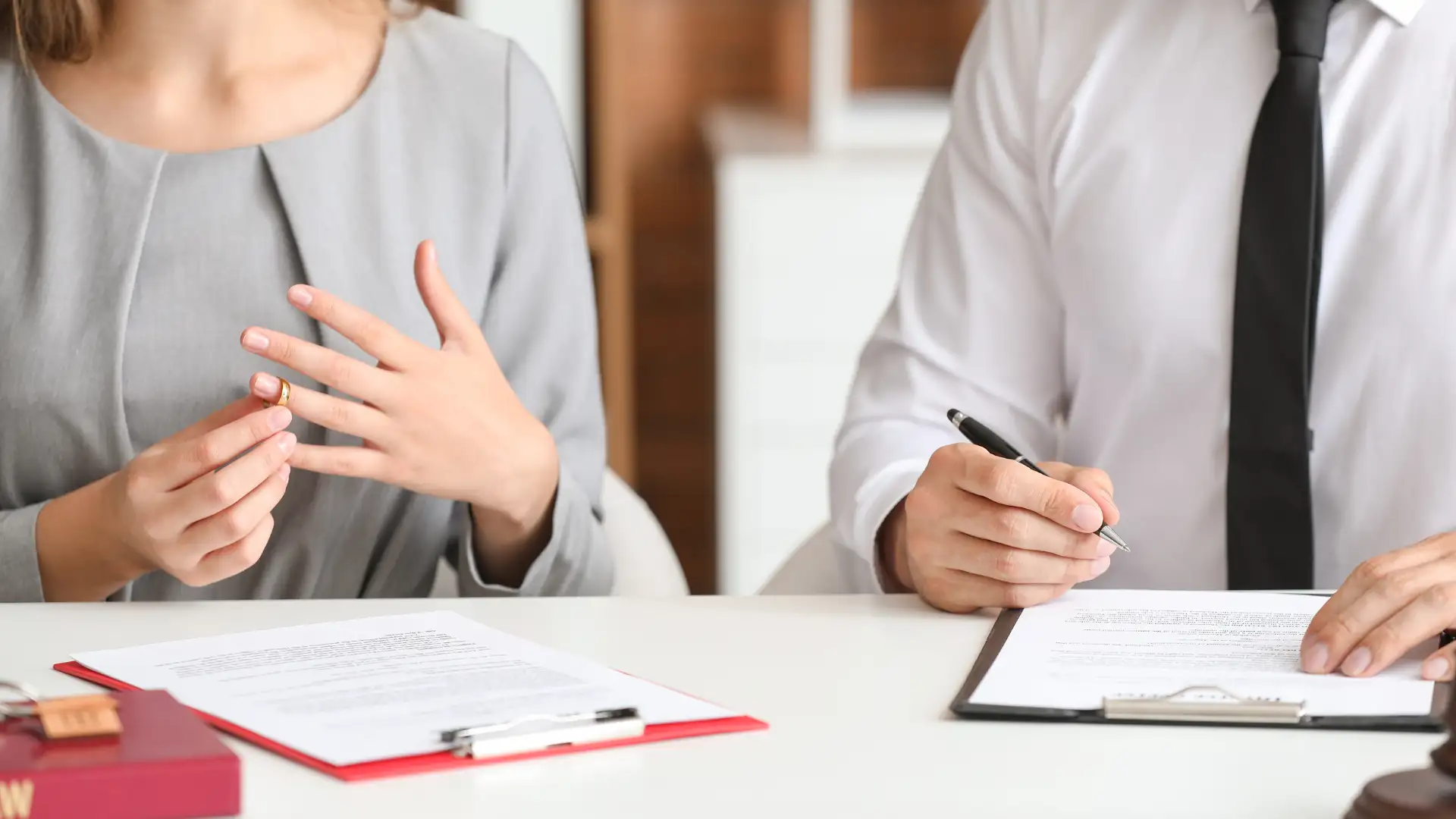 Close-up of two people discussing legal documents in a meeting, possibly for divorce or legal matters.