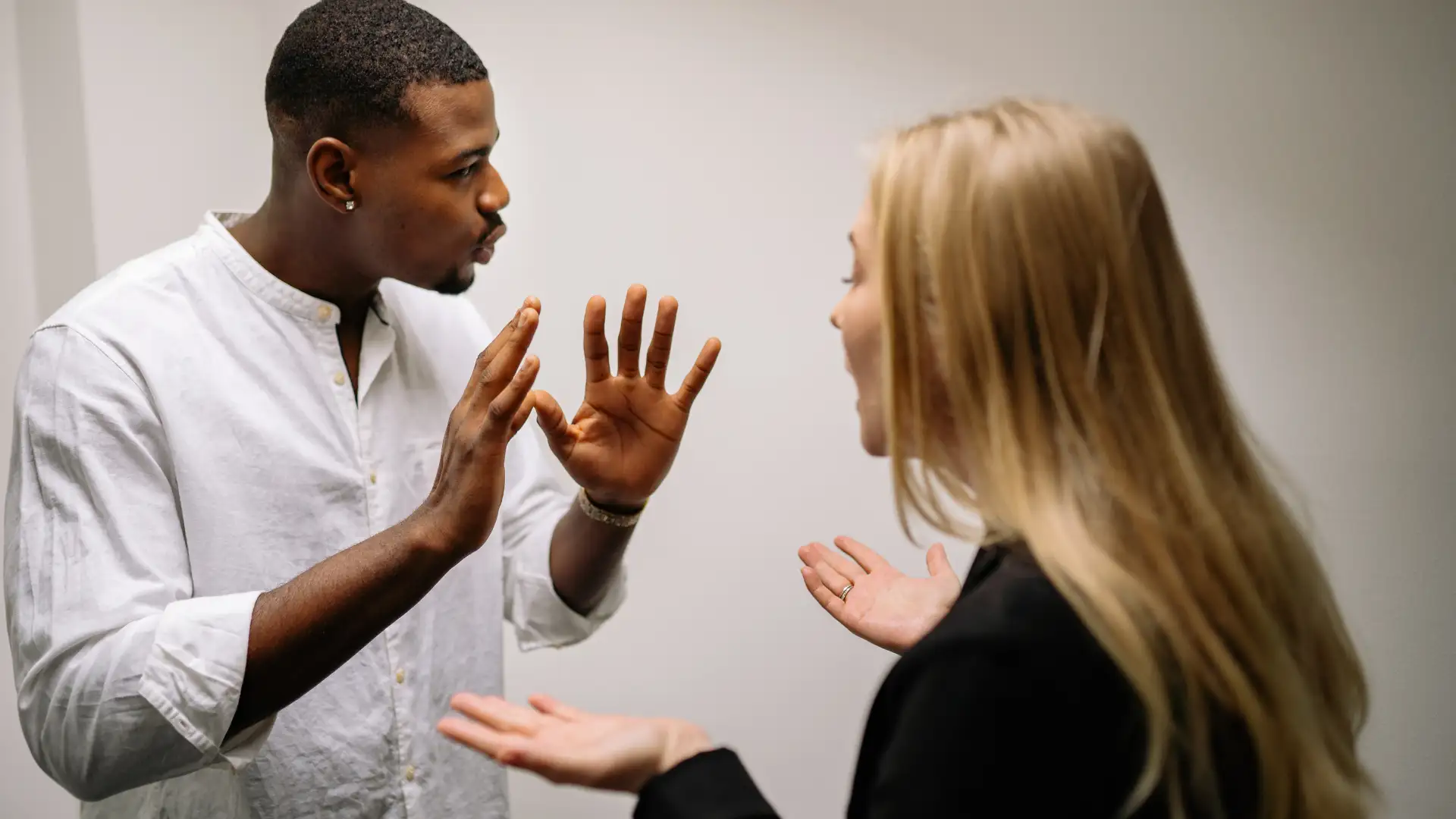 A couple arguing, showing frustration and disagreement, possibly during a heated discussion